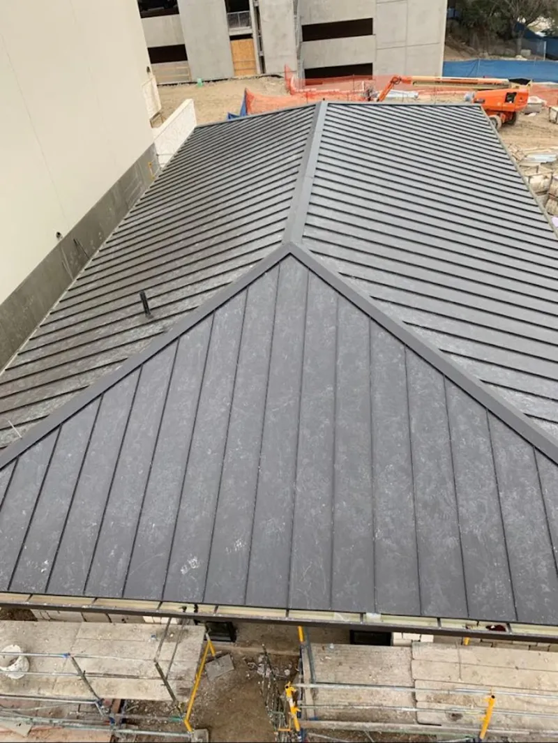 Commercial metal roof construction with crane equipment in Brownsville