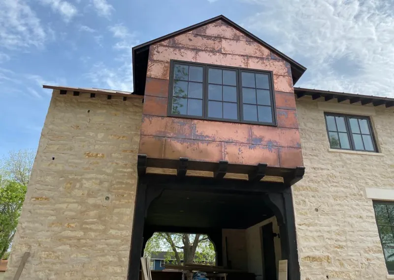 Copper metal panel facade on a stone building for Roof Repair in Brownsville
